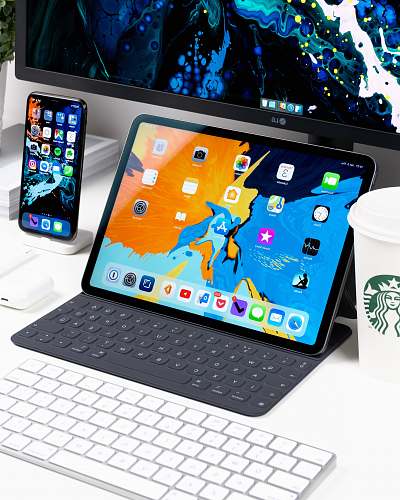 mobile phone black iPad near the white keyboard cell phone